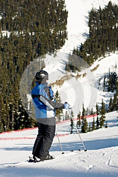 Skier stopped on trail, looking at mountain