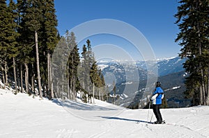 Skier stopped on trail, looking at mountains