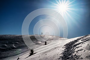 Skier on top of the snowy hill in winter sunny day