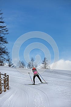 Skier training on the mountain track. Girl cross-country skiing in the mountains.