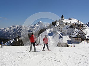 Skiers and alpine village panorama