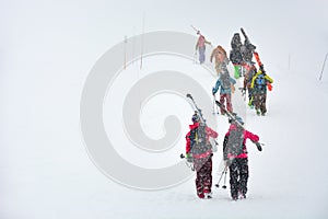 Skiers carries skis and equipments to the track on a slope for skiing on Mount Asahi Asahidake mountain during snowfall