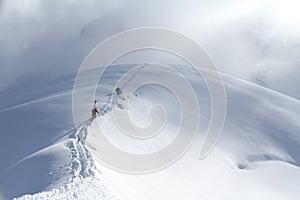 Skiers climbing a snowy mountain