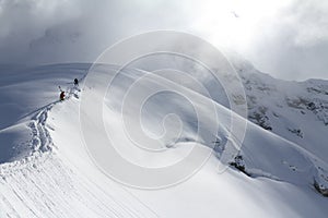 Skiers climbing a snowy mountain