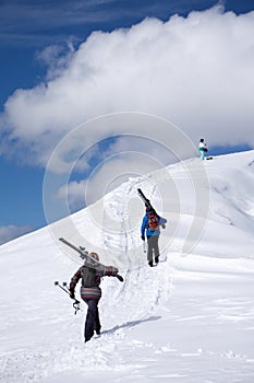 Skiers climbing a snowy mountain