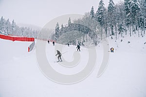 Skiers descend the mountainside along the red fence on the Kolasin 1600 slope. Montenegro