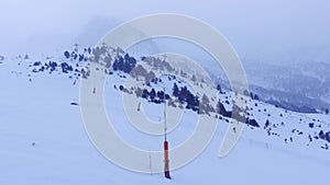 Skiers descending the slope of the ski slope on a cloudy and blizzard day, Andorra, Grandvalira.