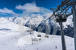 Skiers and double chairlift in Alpine ski resort in Solden