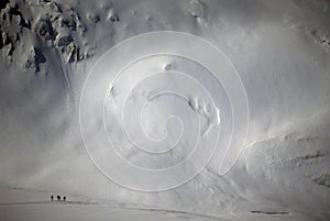 Skiers are dwarfed by the mountain glacier