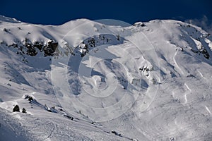 Skiers exploring off piste terrain at the Meribel ski resort in France.