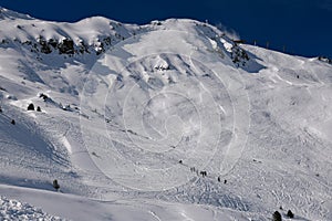 Skiers exploring off piste terrain at the Meribel ski resort in France.