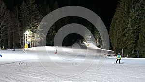 Skiers having fun skiing at night slope track