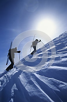 Skiers Hiking To Mountain Summit