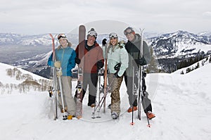 Skiers On Mountain Holding Skis