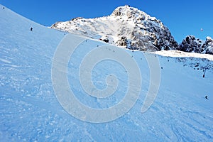 Skiers on mountain slope in winter sunny day in High Tatras.