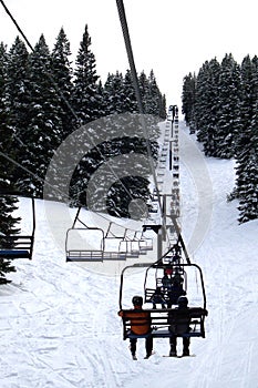 Skiers Riding Up a Chair Lift photo