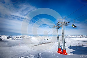 Skiers on ski lift enjoying the view to foggy Alps in Austria and beautiful snowy country panorama in famous Kitzbuehel mountain s