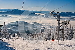 Skiers on ski lift on ski resort on Kubinska Hola during winter