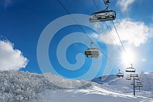 Skiers in a ski lift in snowy mountains