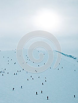 Skiers on ski slope in blizzard snowstorm in mountains on Hintertux Glacier, Zillertal Valley