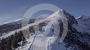 Skiers on ski slope in High Tatras mountains aerial.