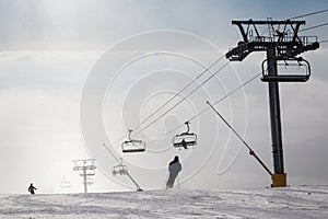 Skiers on ski slopes in fog.