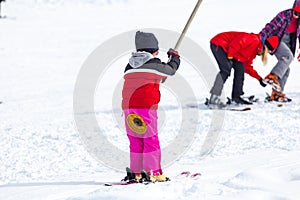 Skiers skiing climb a yoke on a mountain. Light skiing track in Bakuriani