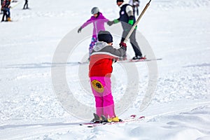 Skiers skiing climb a yoke on a mountain. Light skiing track in Bakuriani