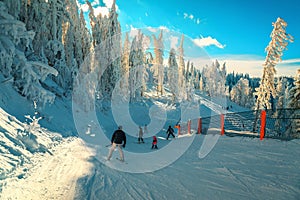 Skiers skiing downhill in Poiana Brasov ski resort, Romania, Europe