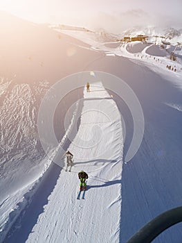 Skiers in the slope under the sun