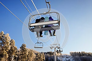 Skiers and snouborders on snow slope in winter ski resort. Ski elevator on snow mountain. Winter activity concept. Cable car ski