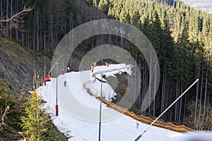 skiers on a snow slope for beginners on a sunny day.