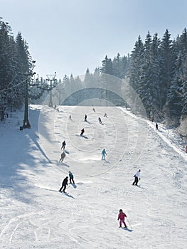 Skiers and snowboarders going down the slope