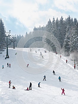 Skiers and snowboarders going down the slope