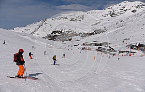 Skiers and snowboarders riding down the slope at the Val Thorens Ski resort in France.