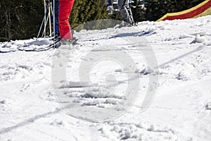 Skiers stand before descending from a ski slope on a sunny day. Active