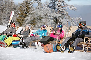 Skiers in sun bad sitting and pausing from skiing photo