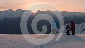 Skiers with thermos and digital camera stand on Aibga ridge