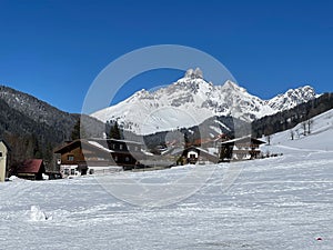 skiers walking down the slopes of a snowy mountain lodge
