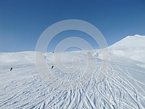 Skiers on wide open piste in French alps photo