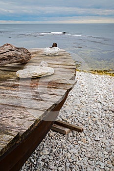 Skiff boat on stone beach by the ocean photo