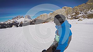 Skiing in the Alps in the winter. A man is rolling on a snowboard on the snow-covered trails of a mountain resort