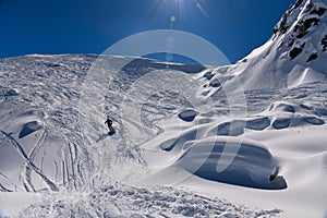 Skiing downhill off piste on the amazing sunny day with fresh snow.