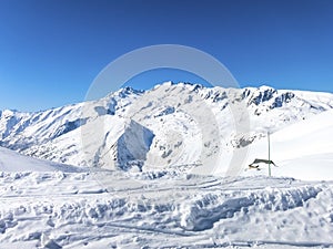 Skiing in French alps with a small hut covered with snow