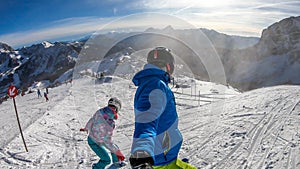 Nassfeld - A snowboarder and a skier going down the slope