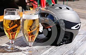 Skiing resort. Glasses of beer and a ski helmet.