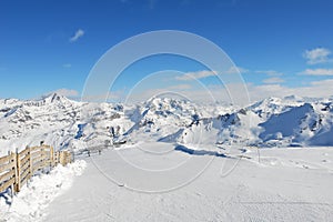 Skiing road on mountain snow slope in Paradiski region photo