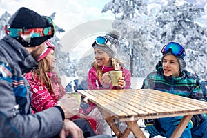 Skiing, winter fun - Family enjoying on hot drink at ski resort