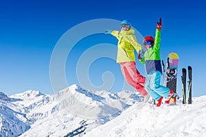 Skiing, winter, snow, sun and fun - kids, boy and girl jumping and having fun in the Alps. Child skiing in the mountains