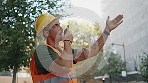 Skilful foreman dictate instructions using portable radio at street closeup